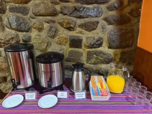 a table with two coffee makers and an orange juice at HOSTAL HUAYNA HOUSE GO in Cusco +34 photos