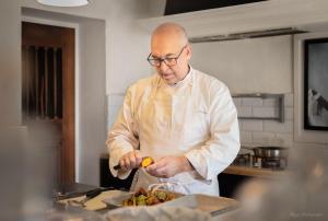 a man is preparing food in a kitchen at Guesthouse Le Mas de Cotignac in Cotignac