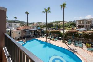a view of a swimming pool on a balcony with palm trees at Gianna Apartments in Almyrida