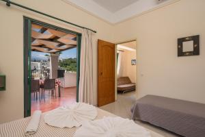 a bedroom with two beds and a view of a balcony at Gianna Apartments in Almyrida +71 photos