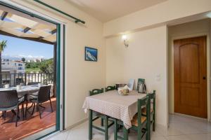 a dining room with a table and chairs and a balcony at Gianna Apartments in Almyrida