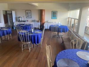 ein Raum mit Tischen und Stühlen mit blauen Tischdecken in der Unterkunft HOTEL ASTORE Matta 2537 in Antofagasta