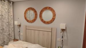 a bedroom with two mirrors on the wall and a bed at Mansilla Petit Inn in Mansilla de las Mulas