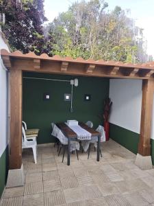 a patio with a table and a wooden pergola at Mansilla Petit Inn in Mansilla de las Mulas