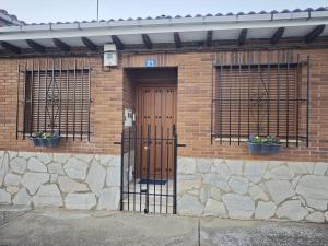 a brick building with a wooden door and two windows at Mansilla Petit Inn in Mansilla de las Mulas +6 photos