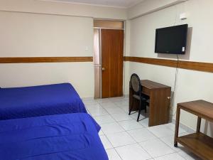 ein Schlafzimmer mit Bett, Schreibtisch und Fernseher in der Unterkunft HOTEL ASTORE Matta 2537 in Antofagasta