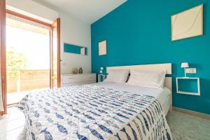 a blue bedroom with a bed with a blue wall at Fiordaliso in Alba Adriatica