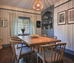 a dining room with a wooden table and chairs at Home Farm Cottage in Peterborough