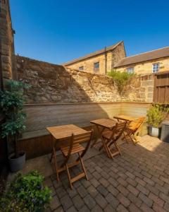 two wooden tables and chairs on a patio at The Hairy Lemon in Alnwick