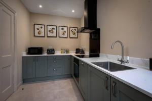 a kitchen with blue cabinets and a sink at Rubens Rooms in Peterborough