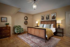 a bedroom with a large bed and a chair at Rubens Rooms in Peterborough