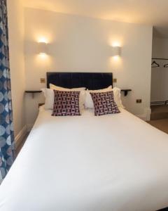 a large white bed with two pillows on it at The Hairy Lemon in Alnwick