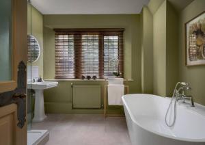 a green bathroom with a tub and a sink at Rubens Rooms in Peterborough +13 photos