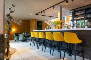 a bar with yellow bar stools in a restaurant at Cozmoss Boutique Hotel in Erica