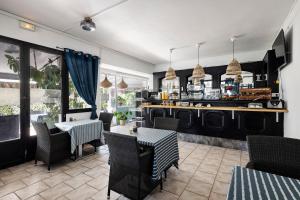a restaurant with tables and chairs and a kitchen at Hotel Le Golfe Bleu in Cavalaire-sur-Mer