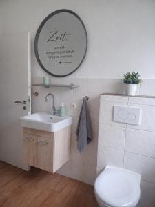 a bathroom with a toilet and a sink and a mirror at Ebenerdiges Ferienhaus für Rückzug und Auszeit mit Sauna, Weitblick, Terrassen, Privatsphäre auf 20000 qm NaturZentral in Frankenberg