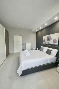 a large bedroom with a large white bed in it at Deluxe Appartment in Cinisi