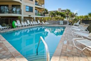 a swimming pool with lounge chairs and a hotel at Gulf Strand Resort by Travel Resort Services in St. Pete Beach