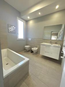 a bathroom with a tub and a sink and a toilet at Deluxe Appartment in Cinisi +21 photos