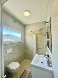 a bathroom with a toilet and a sink and a window at Deluxe Appartment in Cinisi