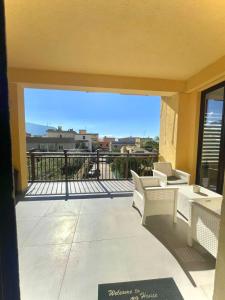 a balcony with white furniture and a view of the city at Deluxe Appartment in Cinisi