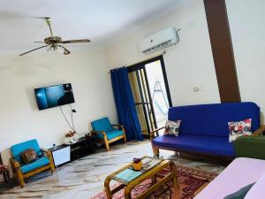 a living room with a blue couch and chairs at Chatet on Casabinca NorthCoast in Dawwār Abū Maḩrūs