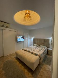 a bedroom with a bed and a large light fixture at Villa avec Piscine Privée à Djerba Dar Jafra in Houmt Souk