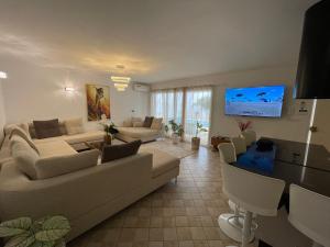 a living room with a couch and a tv at Villa avec Piscine Privée à Djerba Dar Jafra in Houmt Souk