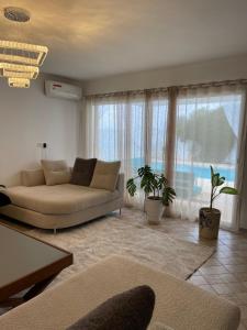 a living room with a couch and a large window at Villa avec Piscine Privée à Djerba Dar Jafra in Houmt Souk