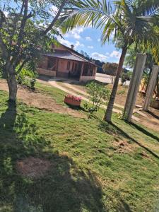 a house with two palm trees in a yard at Cottage Saint Antoine in Pedra Azul +50 photos