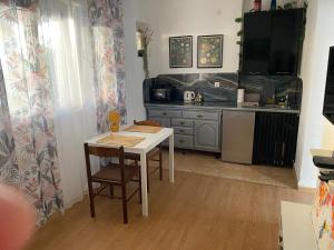 a kitchen with a white table and a kitchen with a counter at Sun Apartment in Tivat
