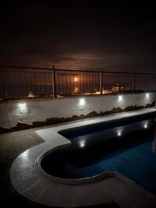 a swimming pool at night with the city in the background at Sunset las hadas in Candelaria