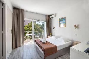 a bedroom with a bed and a large window at Hotel Le Golfe Bleu in Cavalaire-sur-Mer