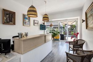 a kitchen with a counter and chairs in a room at Hotel Le Golfe Bleu in Cavalaire-sur-Mer
