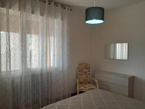 a bedroom with a bed and a window with a chair at Casa Cristina in Ospedaletto Euganeo