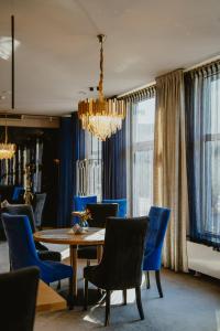 a dining room with a table and blue chairs at Hotel Cristal Park in Tarnów