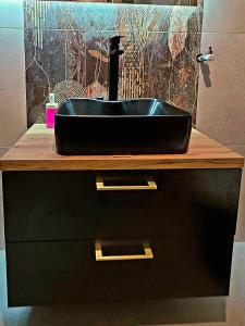 a black sink on top of a counter in a bathroom at Chmielna 5 Rooms & Apartments in Warsaw