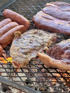 a group of meat and sausages on a grill at Aldea Cardumen in Isla Aguada
