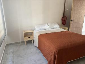 a small bedroom with a bed and a night stand at Aldea Cardumen in Isla Aguada