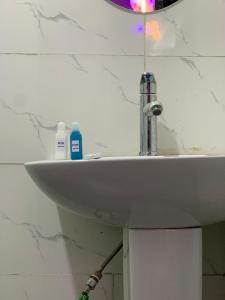 a bathroom sink with two bottles of soap on it at Kris Courts in Ibadan
