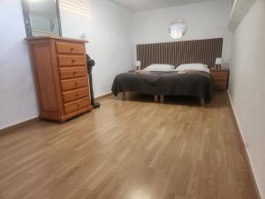 a bedroom with a bed and a wooden dresser at Sunset Balcony with Ocean Views and pool access in Mogán +60 photos