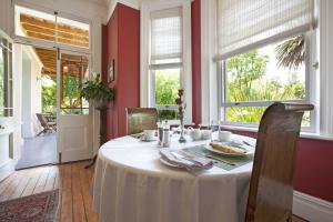 a dining room with a table with a white table cloth at Medindi Manor in Cape Town