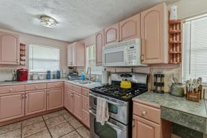 a kitchen with pink cabinets and a stove top oven at Bright 3BR, Dogs, Fenced Yard, FSU & Dwntown in Tallahassee