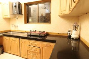 a kitchen with wooden cabinets and a stove in it at Sheth lov villa in Lonavala
