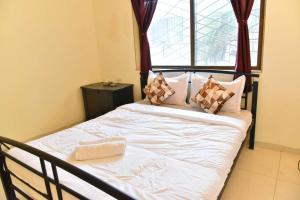 a bed with white sheets and pillows in a bedroom at Sheth lov villa in Lonavala