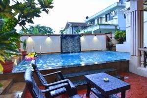 a small swimming pool with two chairs and a table at Sheth lov villa in Lonavala