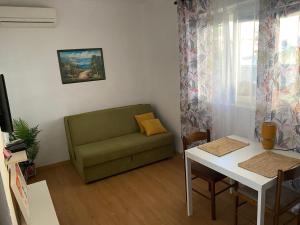 a living room with a green couch and a table at Sun Apartment in Tivat