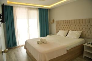 a bedroom with a bed with a teddy bear on it at Pasha Tatil Köyü in Akcaabat