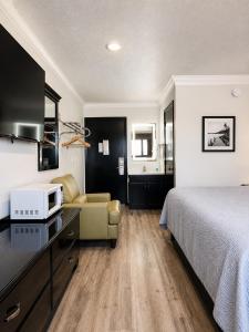 a hotel room with a bed and a microwave at Home Suites in Thief River Falls