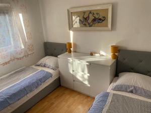 a small bedroom with two beds and a sink at Sun Apartment in Tivat